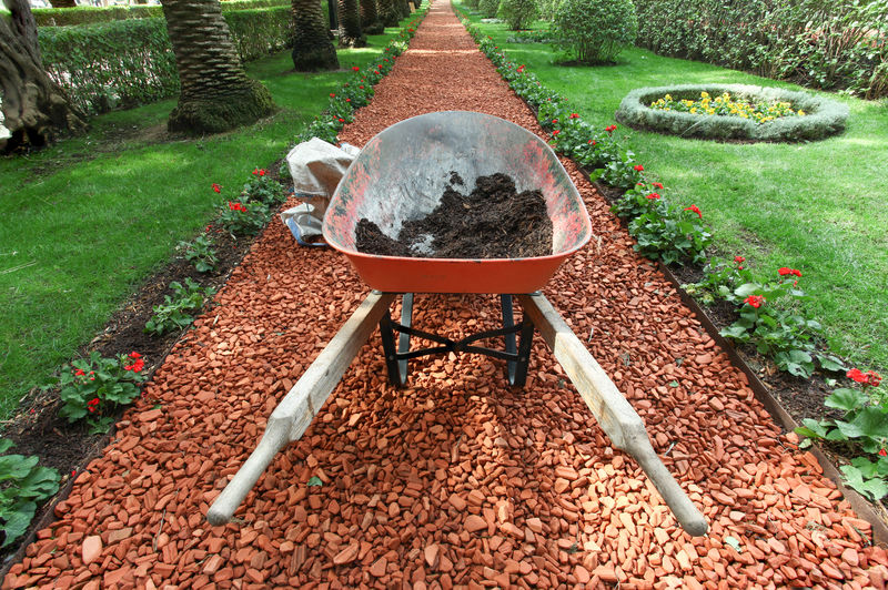 独轮车、泥土和美丽花园的花园工作理念。
