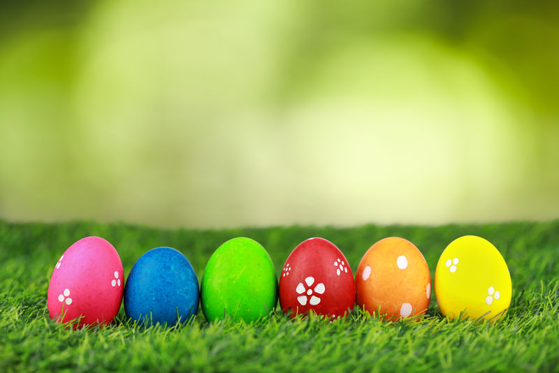 把五颜六色装饰精美的复活节彩蛋放在绿色的草地上