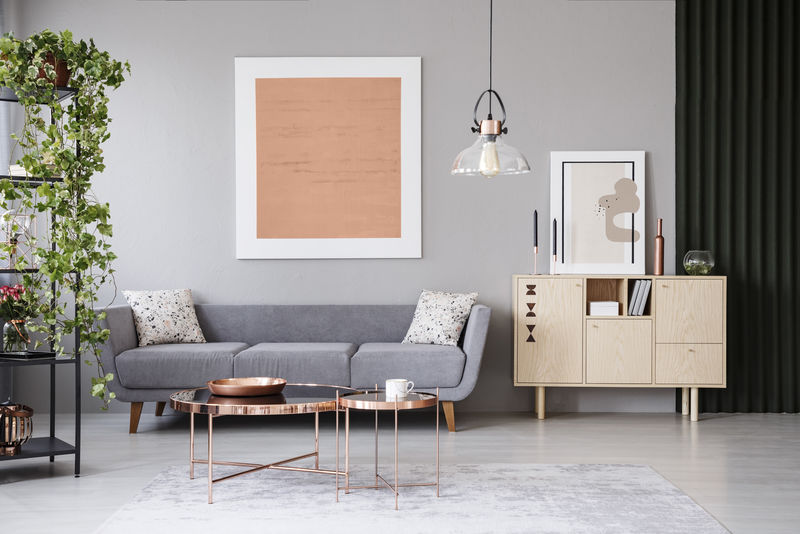 现代公寓室内灰色沙发前的铜桌