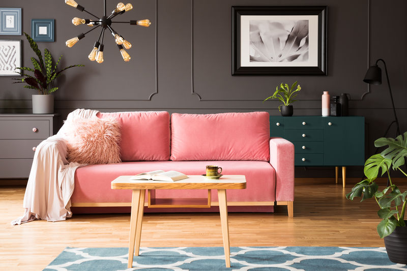 客厅内灰色墙壁上的海报，粉红色沙发和