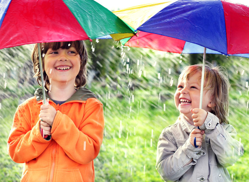 两个快乐的兄弟带着雨伞在户外