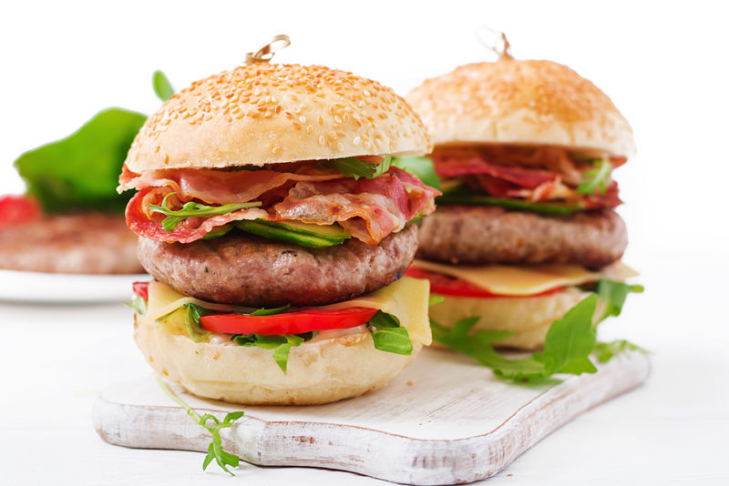 大三明治-汉堡汉堡，配牛肉、奶酪、西红柿、黄瓜和煎培根。