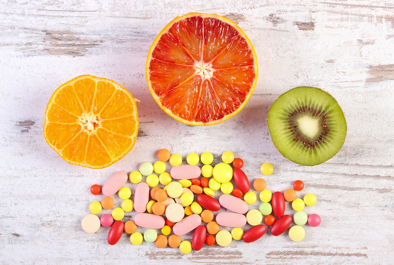 新鲜水果和五颜六色的药丸，健康营养和医疗补充剂的选择