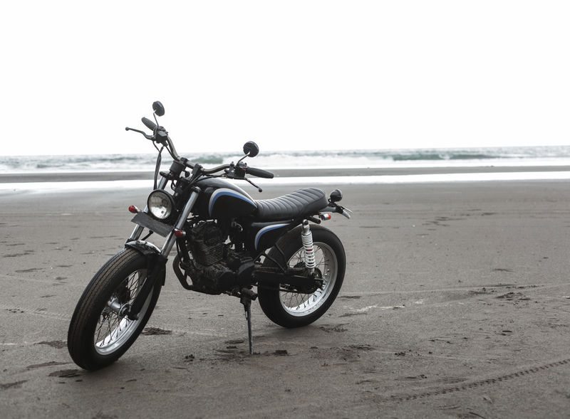 沙滩上日落时的摩托车