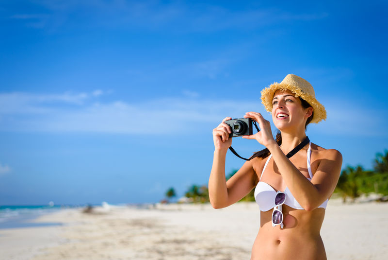 在热带加勒比海海滩拍照的女人