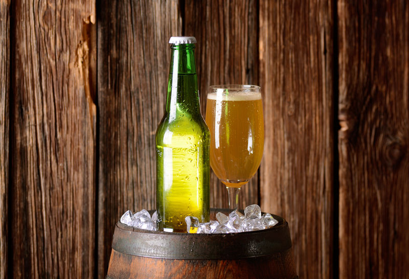 酒杯和啤酒瓶放在装有冰块的桶上