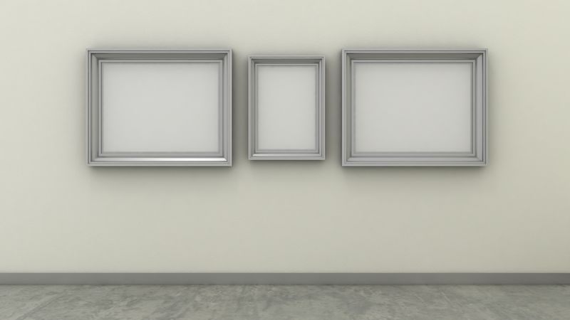 现代室内背景中的空相框，在带混凝土地板的白漆墙上。复制空间图像。