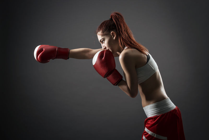 拳击女子在训练前将绷带绑在手上。