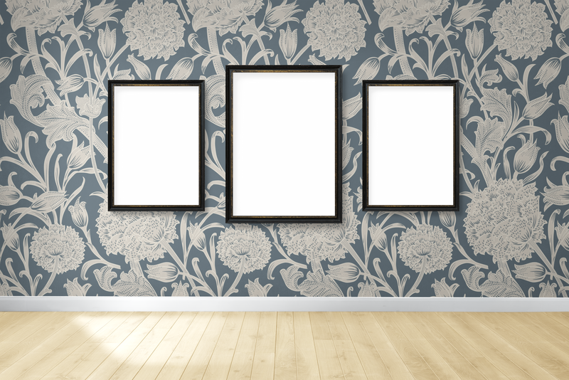 三个空白的黑色相框模型挂在花卉墙纸墙上