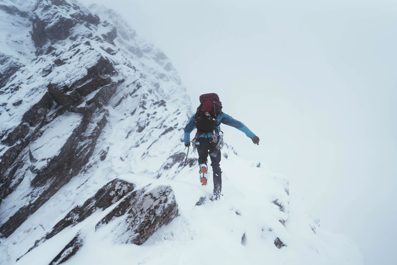 苏格兰格伦希尔一名登山者正在用冰斧攀爬佛肯山脊
