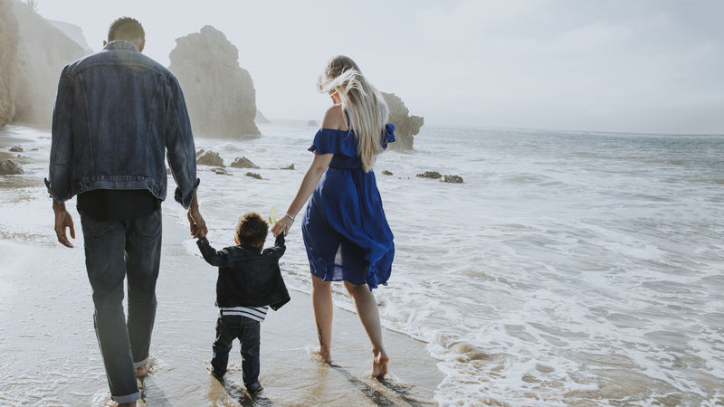 快乐的一家人一起在海滩散步