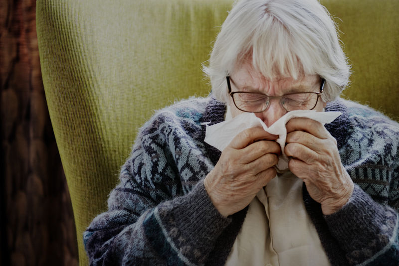 老年妇女打喷嚏并出现covid-19症状
