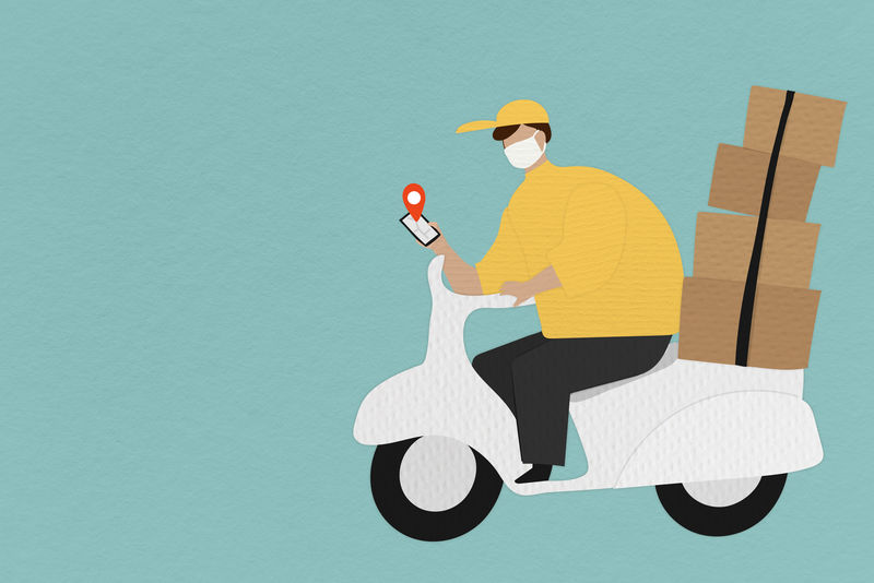 送货员坐在一辆摩托车上拿着包裹盒在手机上查看客户的位置