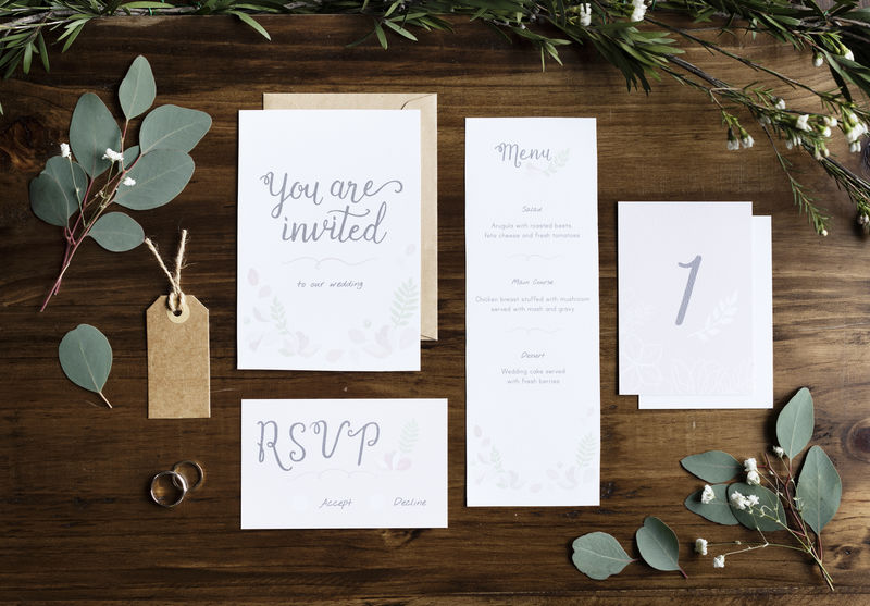 婚礼请柬纸放在桌上用树叶装饰