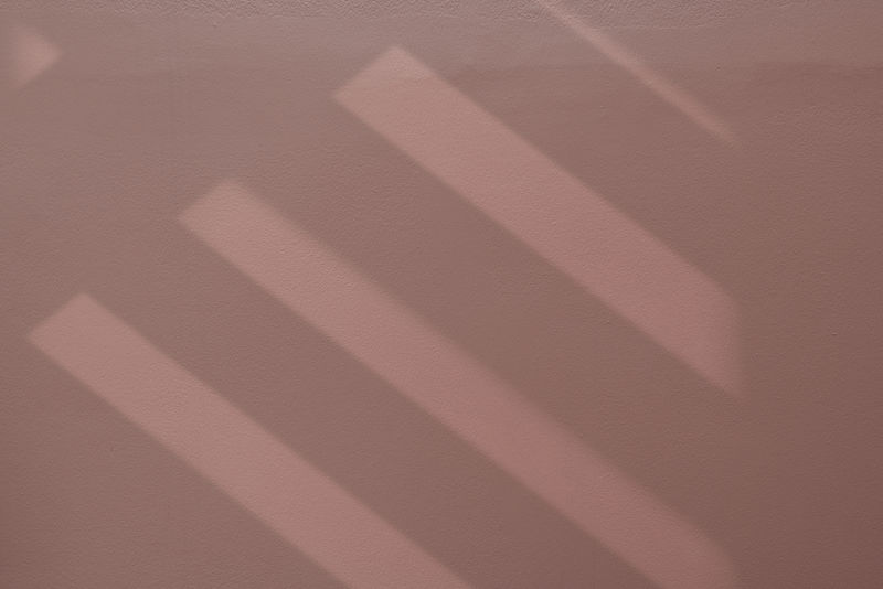 干净粉红色纹理墙上的楼梯阴影