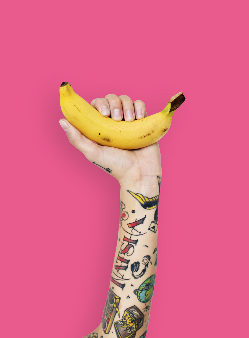 手上有纹身的拿着香蕉的手