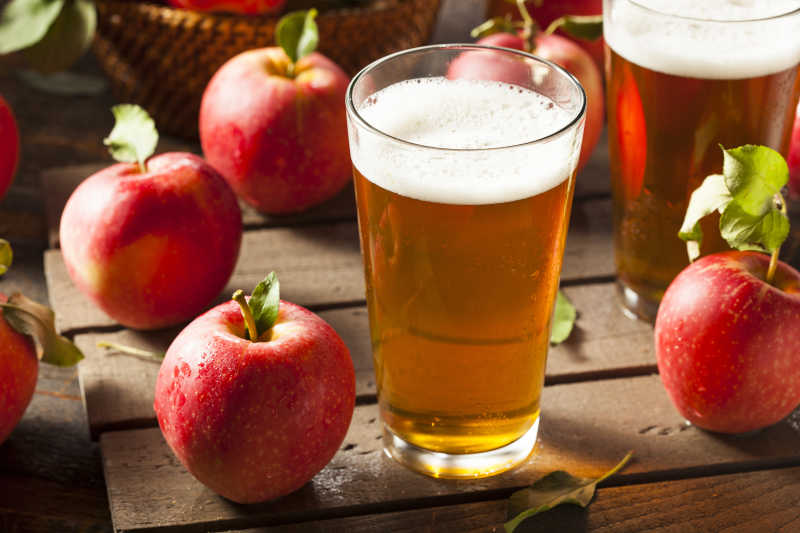 桌子上的新鲜红苹果和啤酒