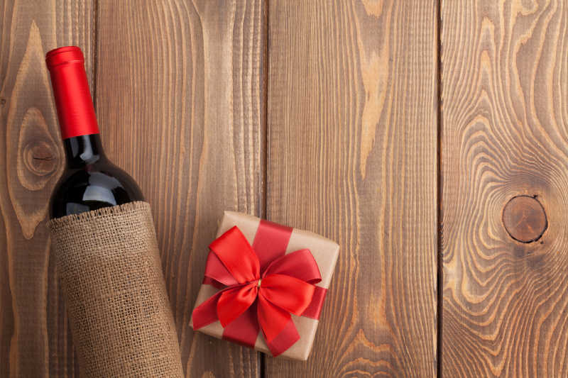 木板上红酒瓶和情人节礼盒
