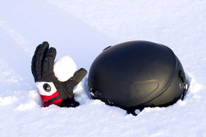 雪崩后被雪覆盖的手套和头盔