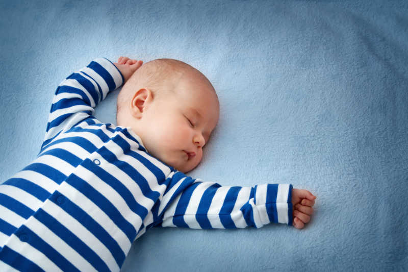 睡在柔软的蓝色毯子上的婴儿