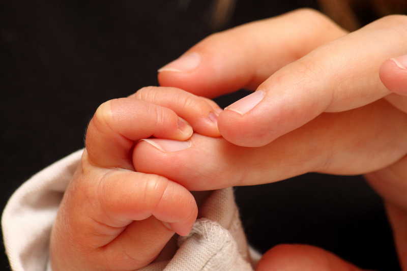 新生儿抓着母亲的手指