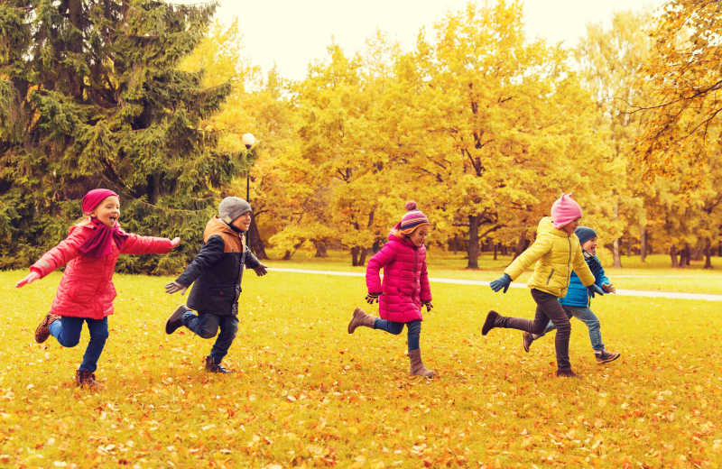秋季公园里一起玩树叶的孩子们