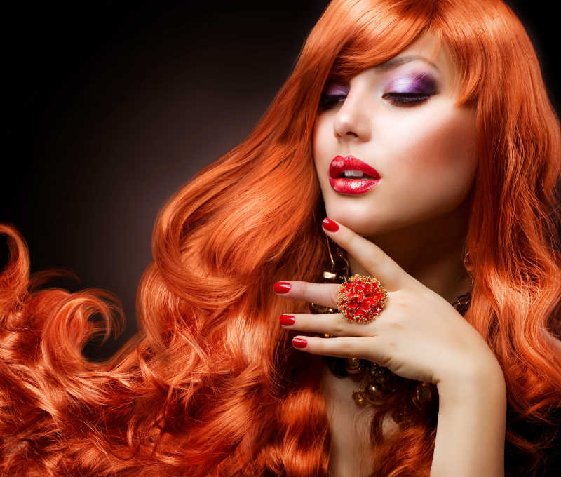 时尚女孩的波浪状的红色头发肖像