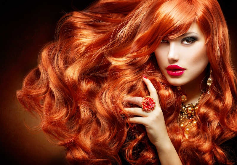 长长的卷曲的红头发的时尚女孩肖像