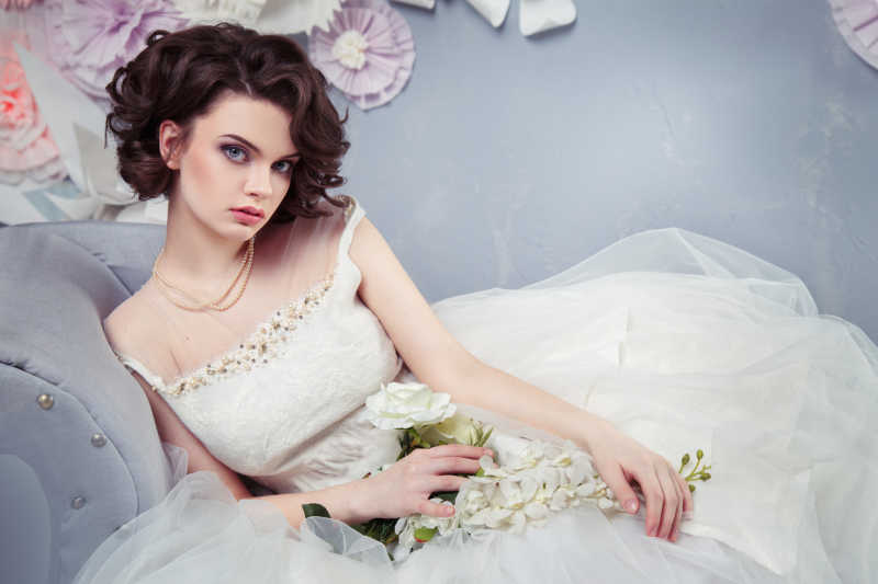 沙发上穿白婚纱的美丽新娘