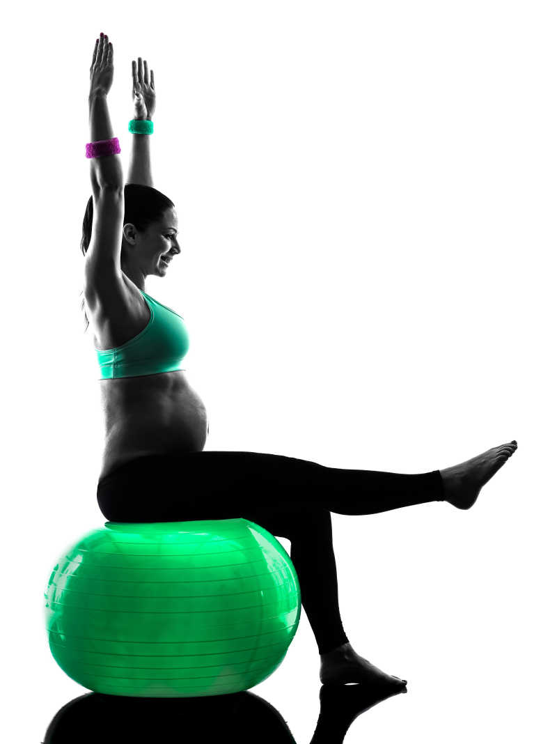 坐在瑜伽球上的孕妇