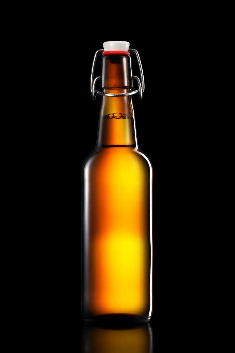 黑色背景下的橘色啤酒瓶