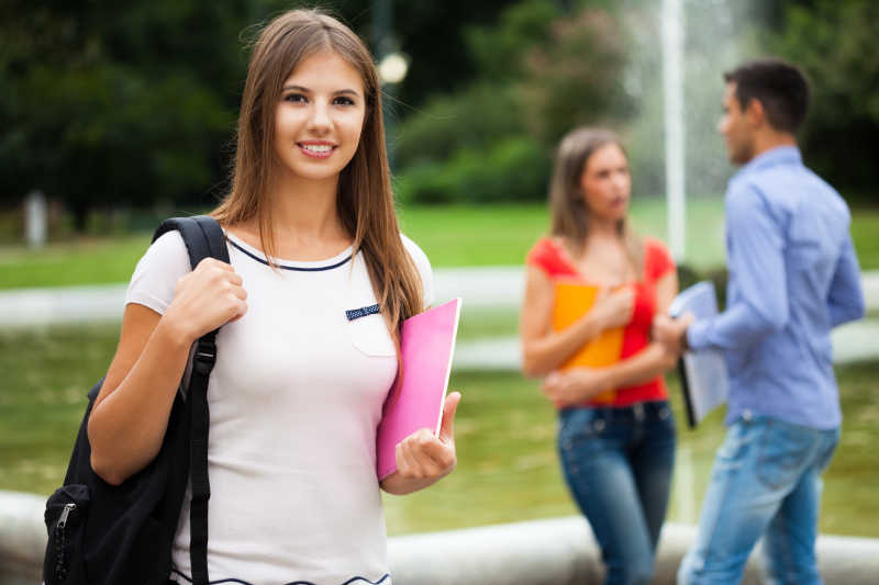 一个美丽的微笑的女学生和她的同学