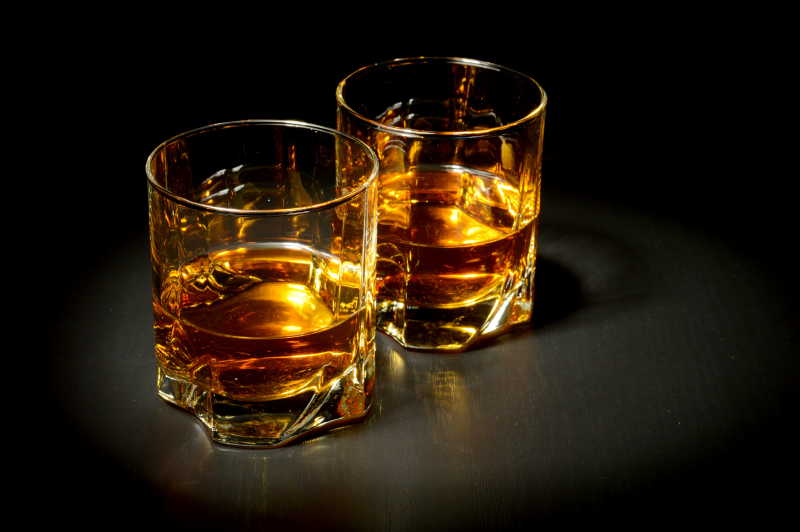 黑桌子上的两杯威士忌