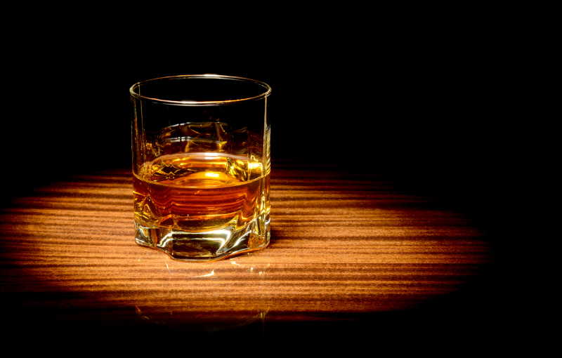 聚光灯下的玻璃杯中威士忌