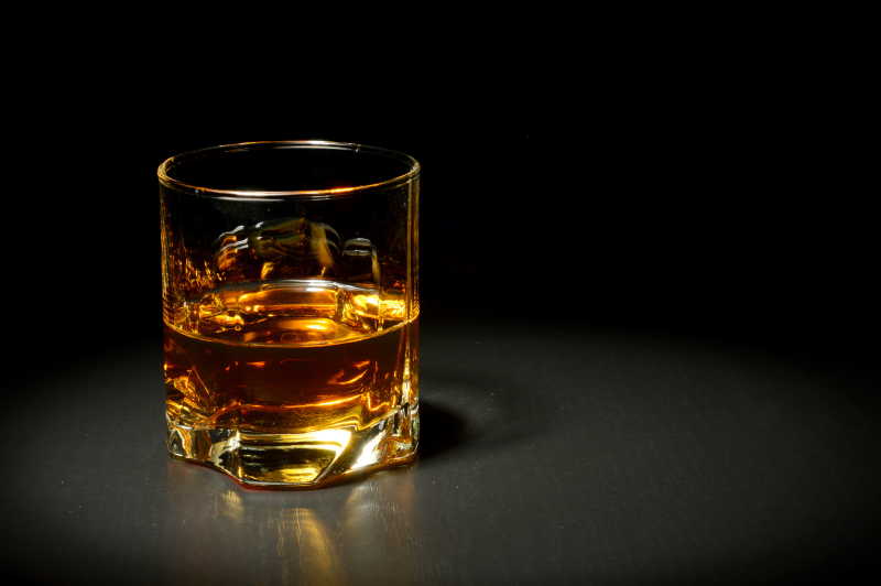 黑桌上的的一杯威士忌