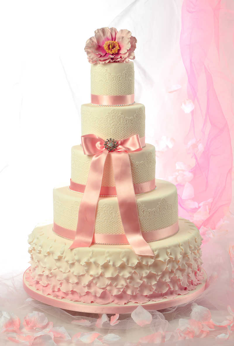 用花朵和蝴蝶结装饰的白色蕾丝蛋糕