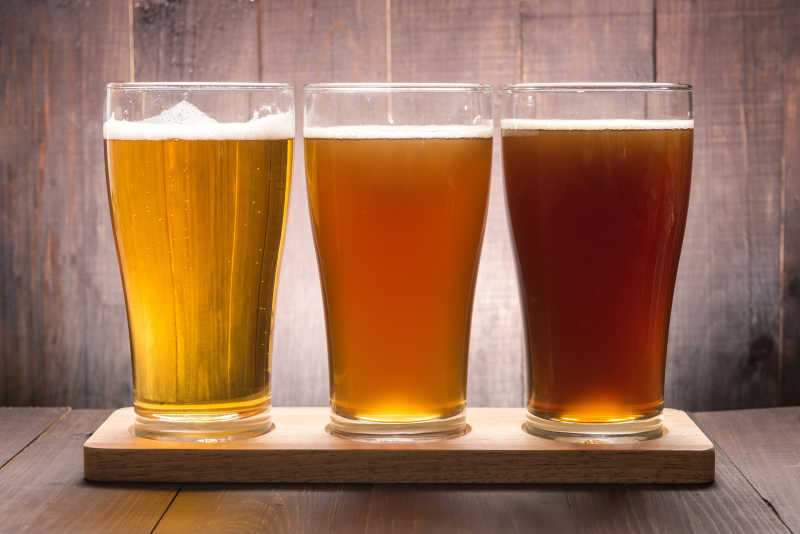 木桌上三种品质的新鲜啤酒