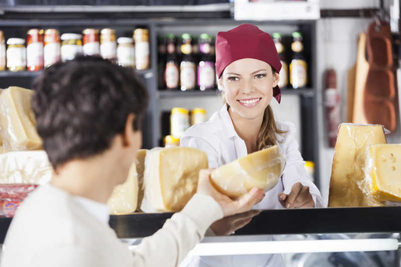 在杂货店卖奶酪给男人的女售货员