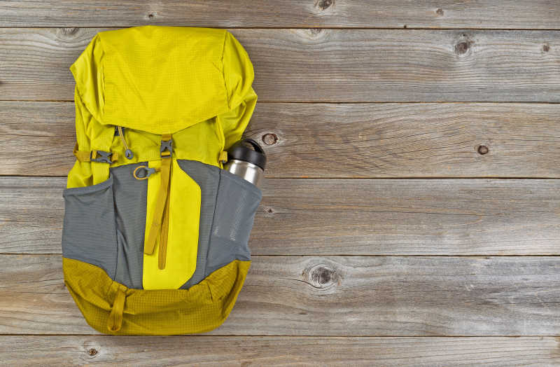 木板上的荧光黄色徒步旅行用防风雨背包