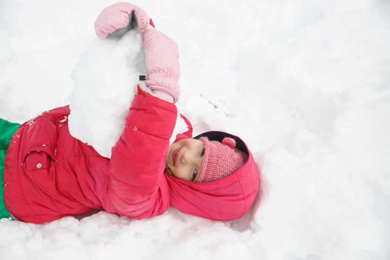 躺在雪地中玩耍的女孩