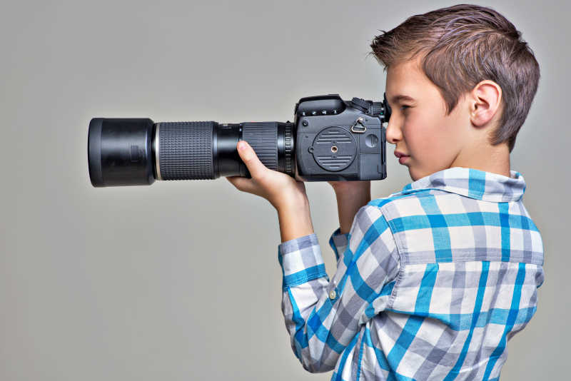 小男孩用数码单反相机拍照