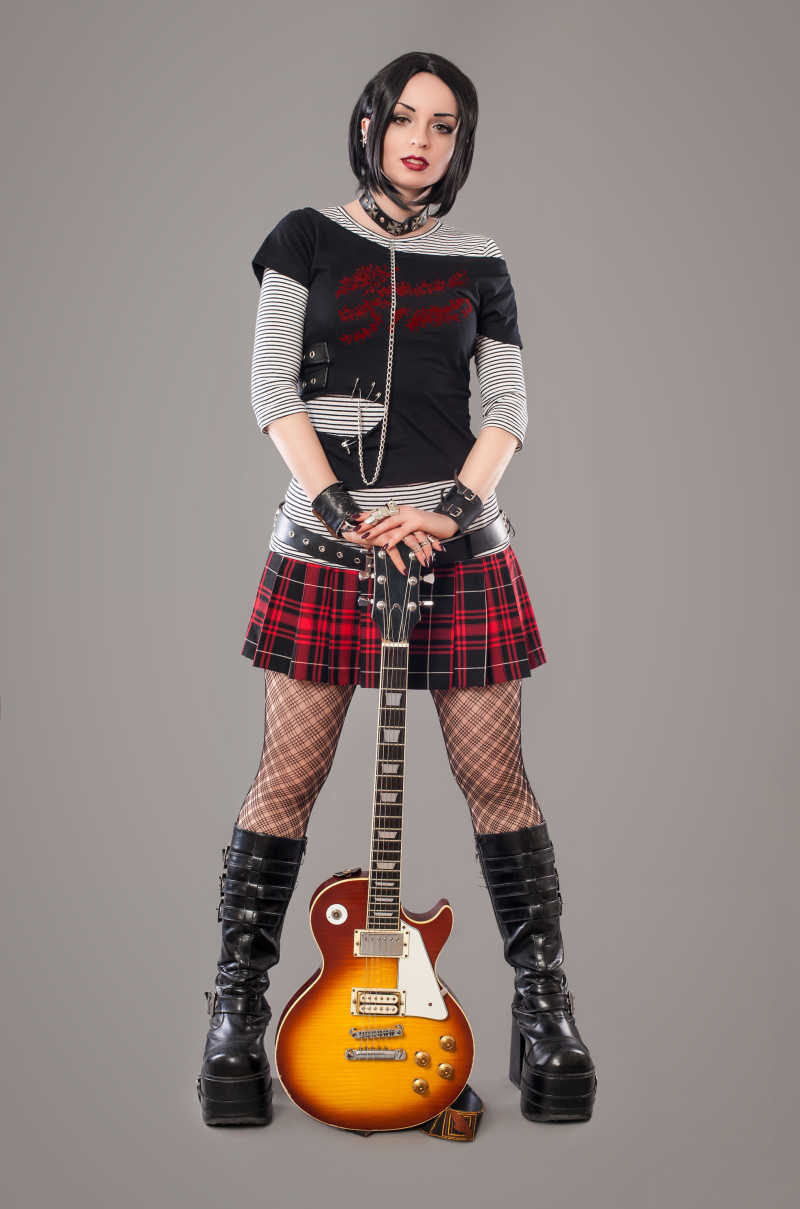 穿着短裙的哥特式女子拿着吉他