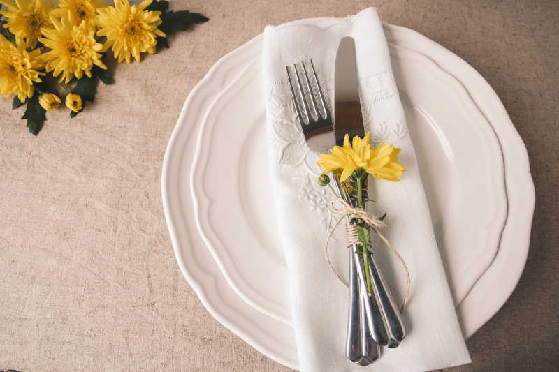 餐桌上餐盘上的餐具和花朵装饰摆设