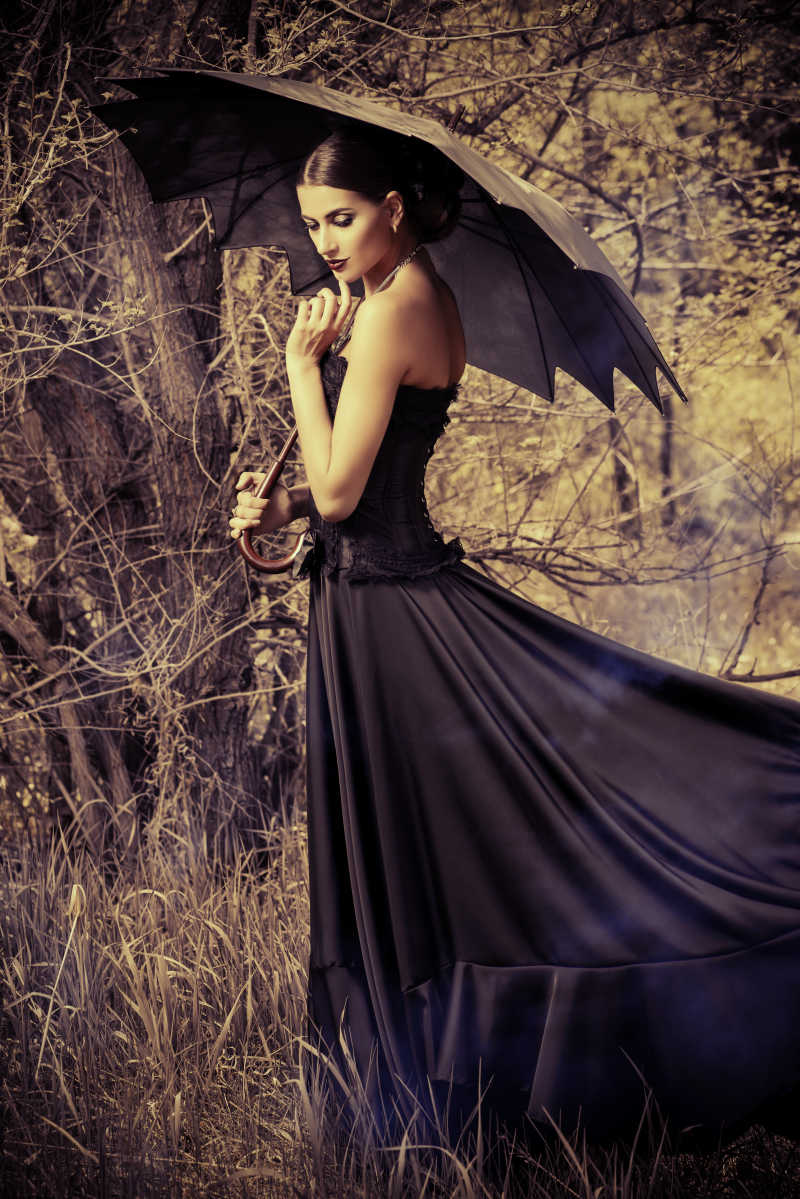 戏剧风格淑女在森林中打着黑伞