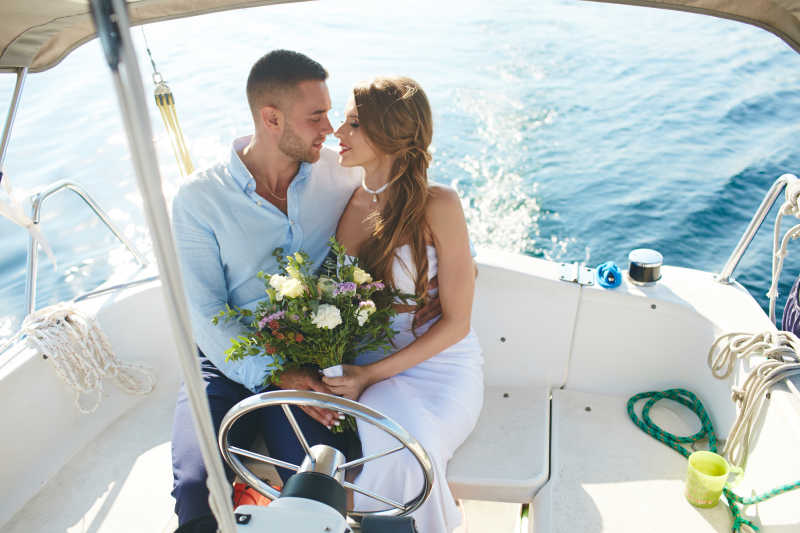 坐在游艇上的浪漫的新郎和新娘