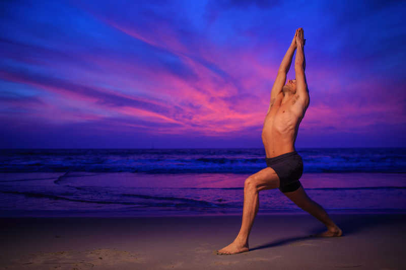 黄昏在沙滩练习瑜伽