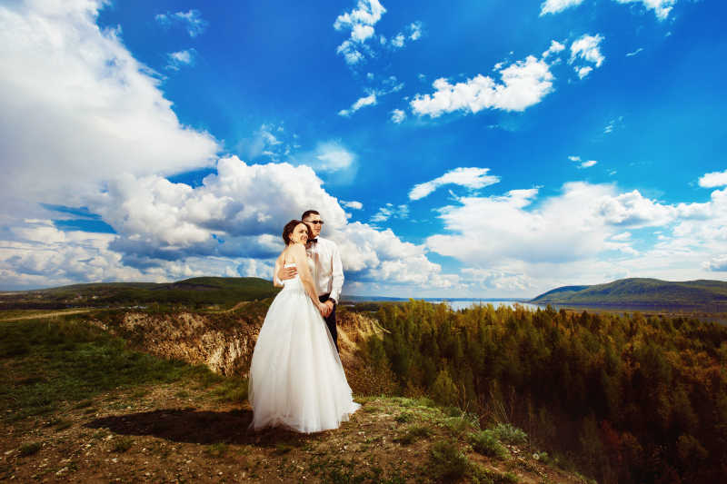 山崖前拍婚纱照的夫妇