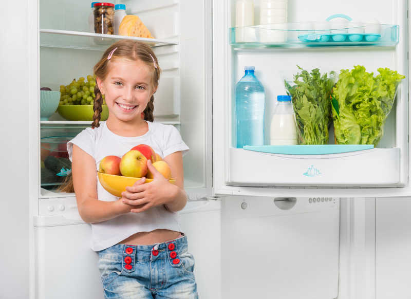 小女孩从冰箱里拿出苹果