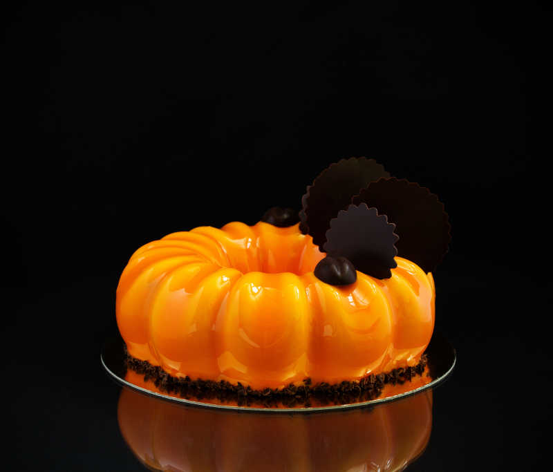 黑色背景下的亮橘色小蛋糕