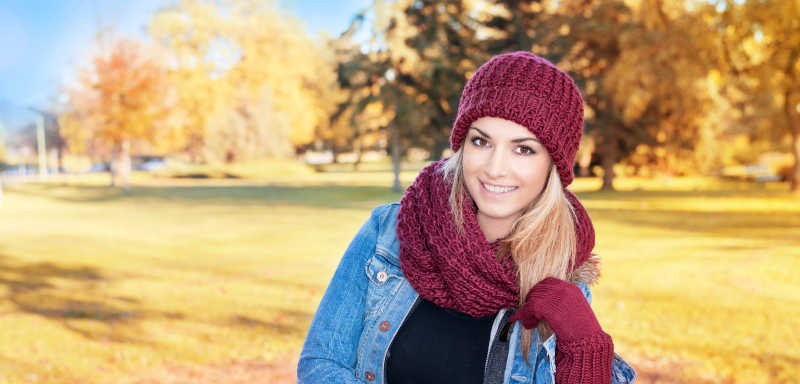 秋天公园里戴着红色帽子和围巾的美女